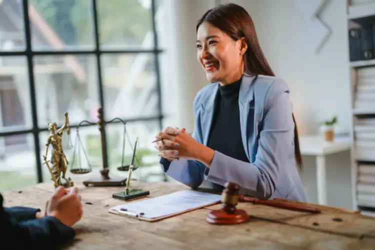  Lawyer smiling and discussing probate advance details with client in office.
